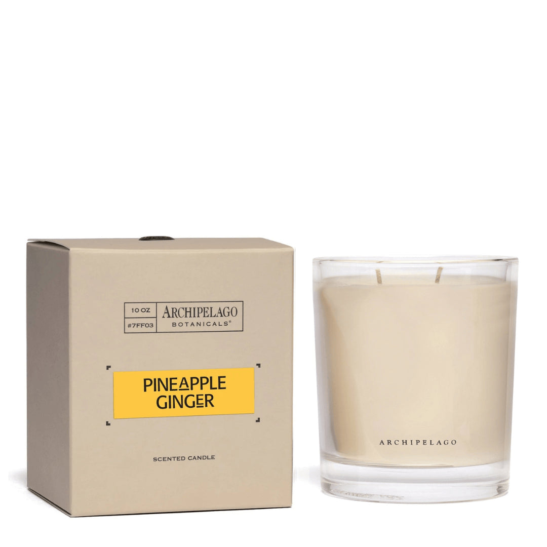 The Pineapple Ginger Credenza Candle in a clear glass jar comes with a beige Archipelago Botanicals box, brightening your space with its lively tropical pineapple and ginger scent. - image 1