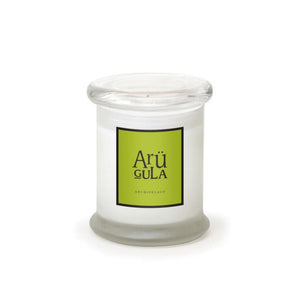 The Arugula Frosted Jar Candle is a white, hand-poured candle in a clear glass jar with a flat lid. Its label reads “Arü GULA” in black on bright green, with “ARCHIPELAGO” below, all set against a plain white background.1