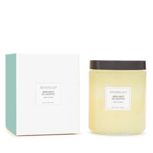 A jar of Bergamot Eucalyptus Body Scrub, enriched with natural oils, sits beside its white and teal packaging box—both bearing the product name in minimalist black text—making it an inviting addition to any self-care routine.1