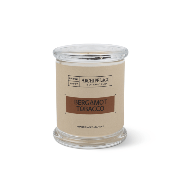 The Bergamot Tobacco Jar Candle features Italian Bergamot and Tobacco Flower notes. Made with premium soy wax, it comes in a clear glass jar with a beige and brown label and matching lid by Archipelago Botanicals.