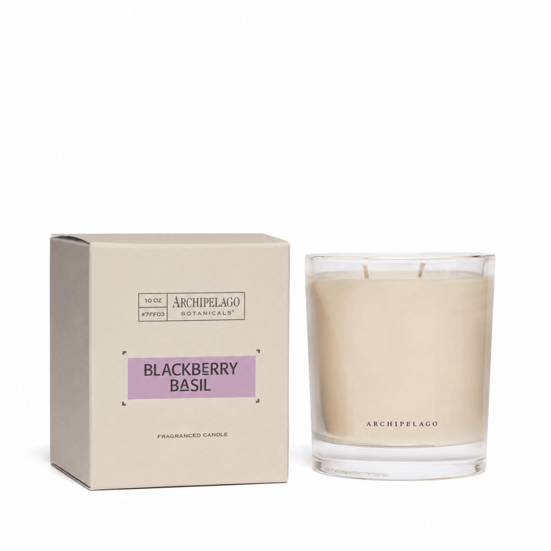 A hand-poured Blackberry Basil Credenza Candle sits beside its light beige box with a purple label, reading Archipelago Botanicals, Blackberry Basil, Fragranced Candle. The premium wax blend comes in this elegant packaging.1
