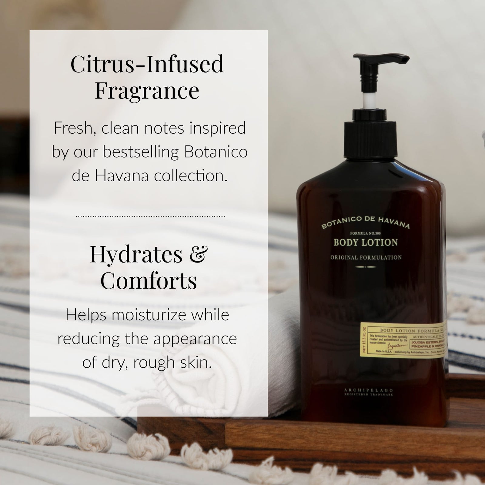 A brown bottle of Botanico de Havana Body Lotion rests on a wooden tray. The product, enriched with a citrus-infused fragrance, hydrates and comforts skin while reducing dryness. Formulated with natural beauty ingredients, this lotion is designed to deeply moisturize dry skin. In the background, you can see a white towel and a bed.7