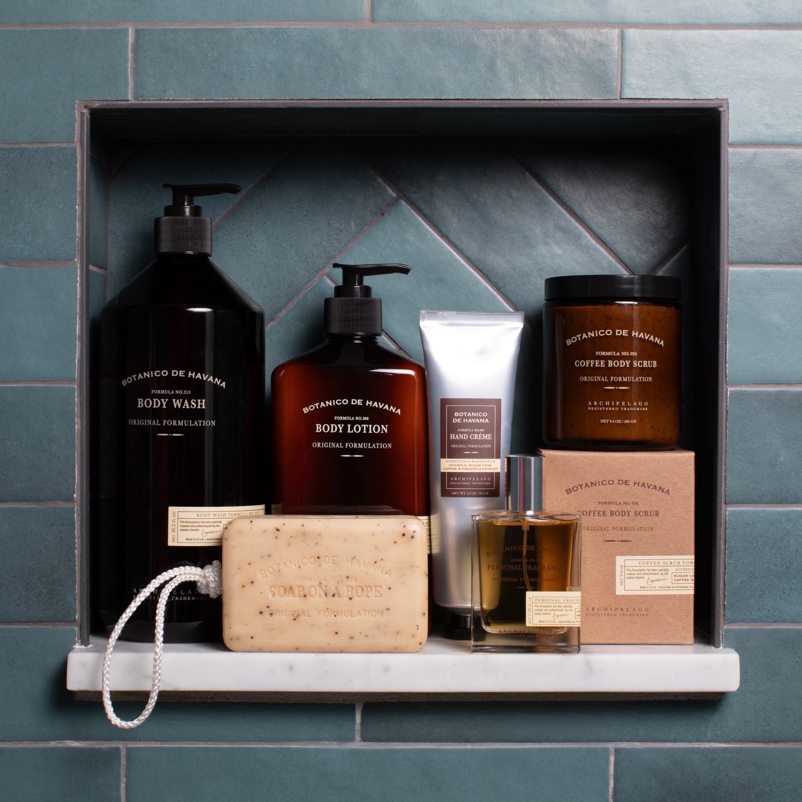 A shelf featuring Botanico de Havana Body Lotion sits against teal herringbone tiles—a harmonious display that highlights natural beauty ingredients for your daily rituals.6