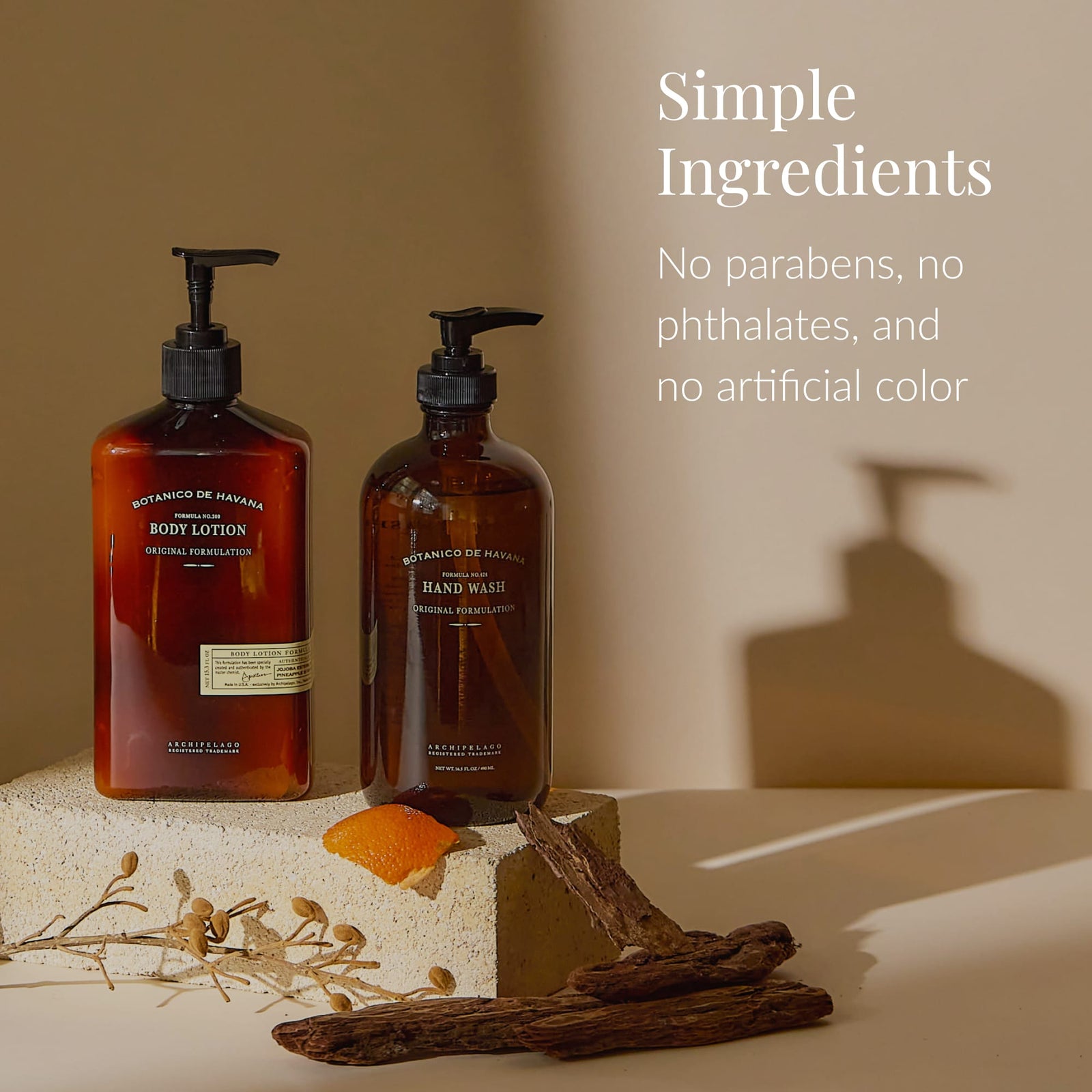 Two amber pump bottles of Botanico de Havana Body Lotion are displayed on beige blocks, accompanied by a dried orange peel, a stick, and a pod. Text reads: Simple Ingredients. No parabens, no phthalates, and no artificial color. Infused with natural beauty ingredients and a refreshing citrus fragrance for an uplifting daily ritual.2
