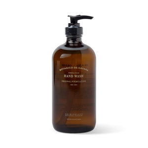 A brown glass bottle labeled Botanico de Havana Hand Wash, set on a white background. This hand wash infuses your daily routine with a hint of luxury and citrus freshness.1