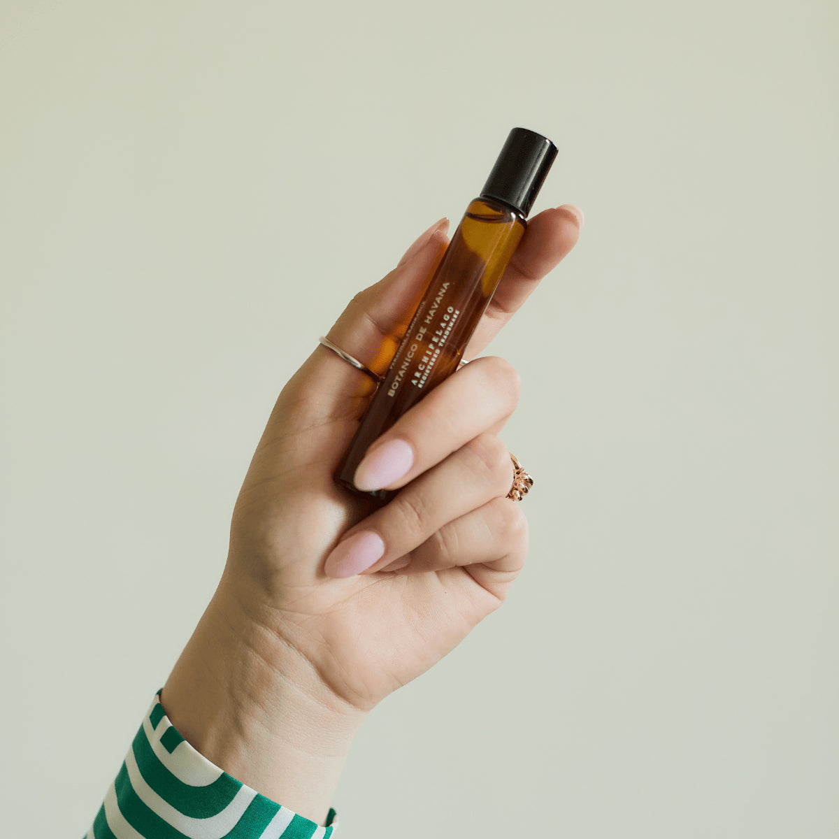 Hand holding fragrance roller bottle on light background2