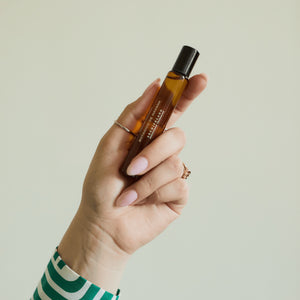 Hand holding fragrance roller bottle on light background2