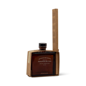 Amber glass bottle of Botanico de Havana Reed Diffuser oil partially encased in a kraft paper box. - image 3