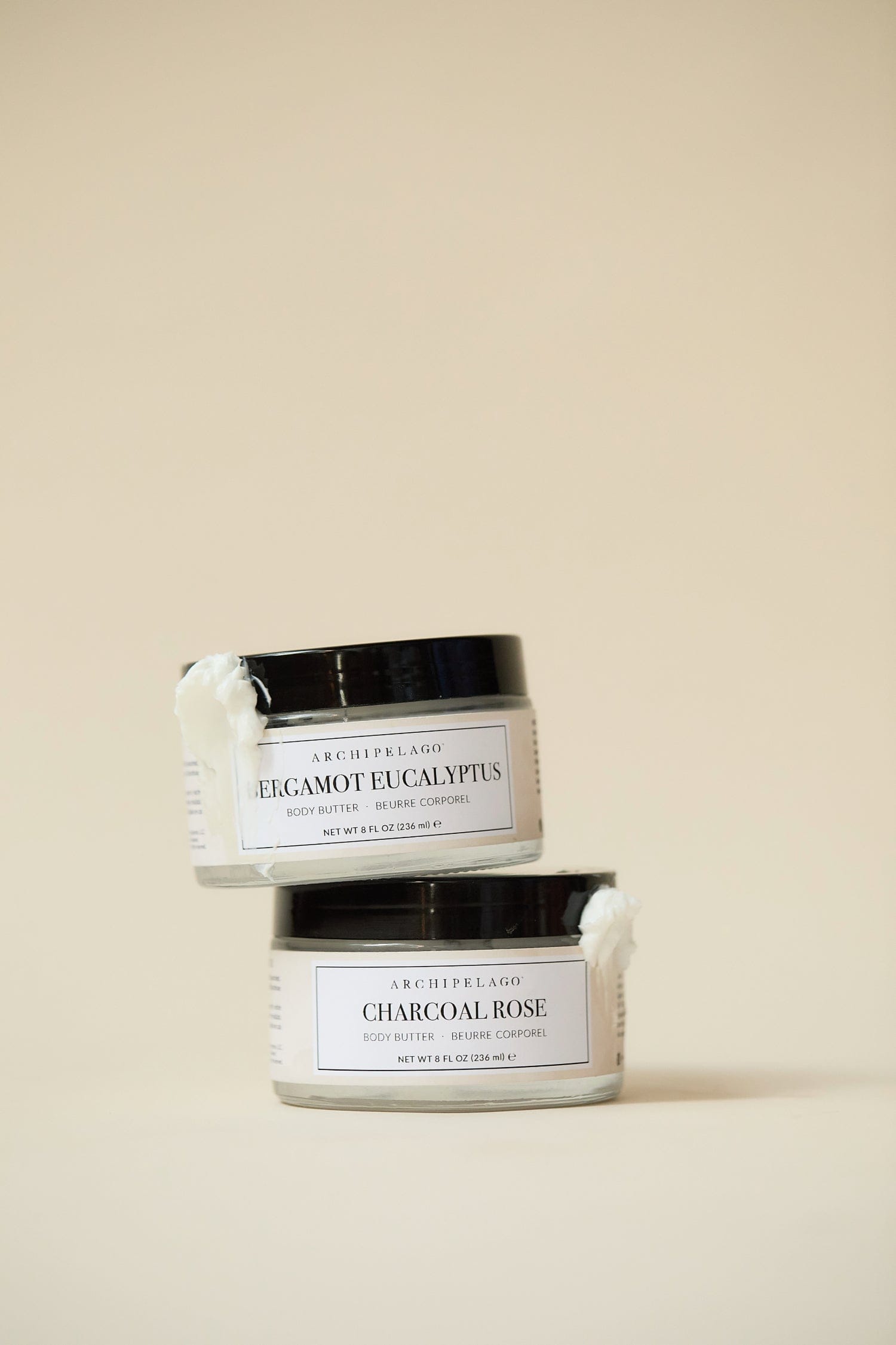 Two jars of Archipelago Body Butter on a beige background3