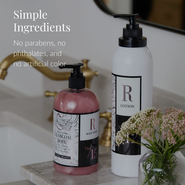 Two pump bottles labeled Body Wash and Charcoal Rose Body Lotion sit on a bathroom counter next to a vase with small flowers. Text reads: Simple ingredients. No parabens, no phthalates, and no artificial color. Powered by activated charcoal for a naturally refreshing cleanse.