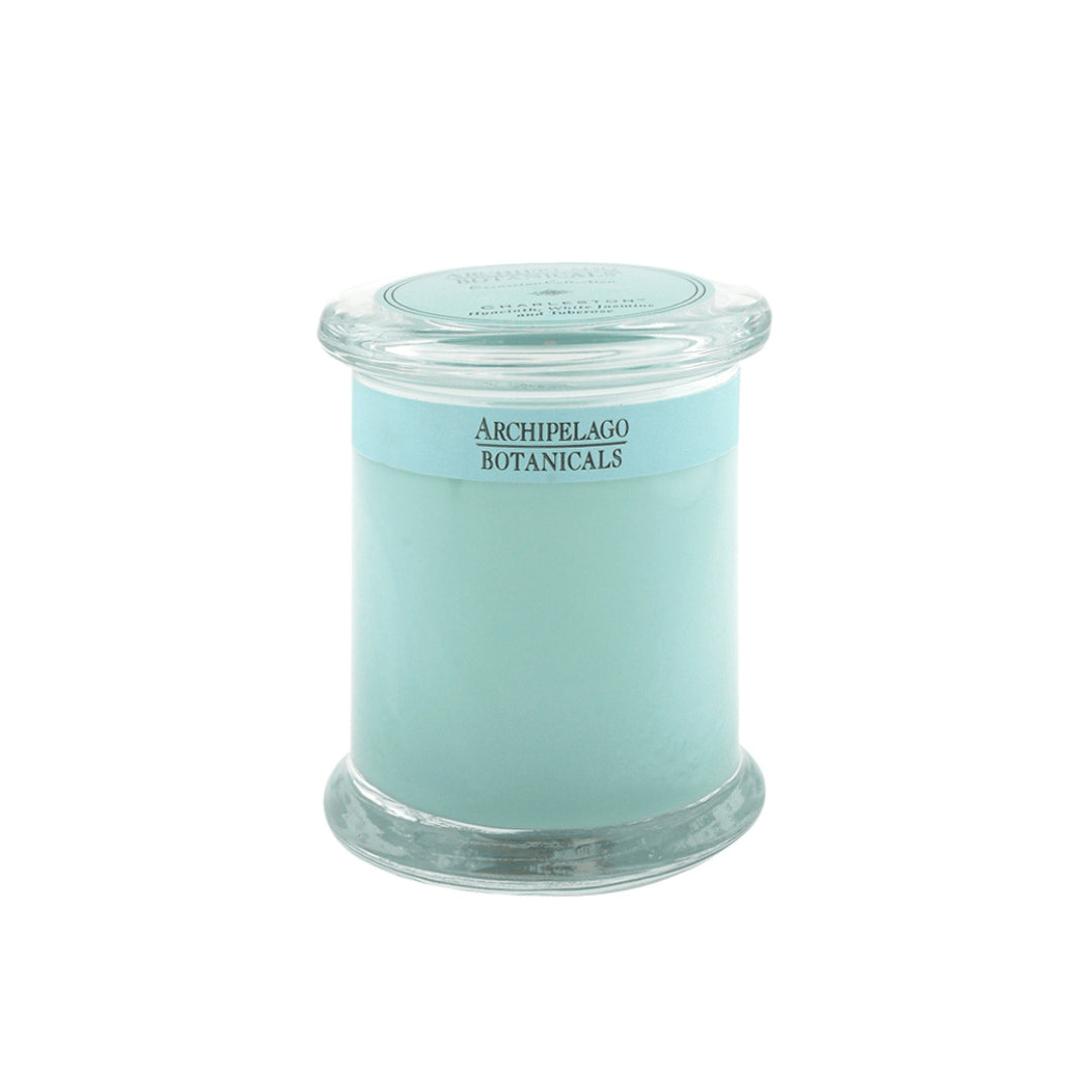 The Charleston Jar Candle features pale blue hand-poured wax in a clear glass jar with a matching lid. Its Archipelago Botanicals label and delicate floral fragrance fill your space with elegance.1