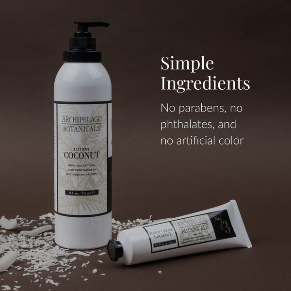 Two white bottles of Coconut Body Lotion by Archipelago Botanicals rest on a brown background scattered with coconut flakes. Text: Simple Ingredients. Infused with Coconut Oil and Jojoba Esters. Free from parabens, phthalates, and artificial colors.
