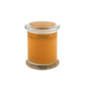 The Dubai Jar Candle features amber-colored wax in a glass jar with a lid and is labeled Archipelago Botanicals—perfect for creating an inviting home fragrance in any space.1