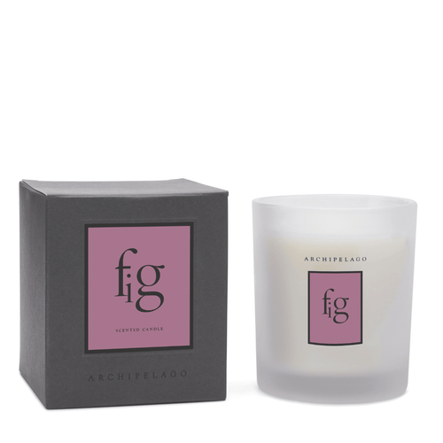 A frosted glass candle labeled “Fig Boxed Candle” stands by its matching gray box with a pink label. Both feature the Archipelago brand and “Scented Candle,” highlighting the modern fragrance of fig and ripe persimmon.