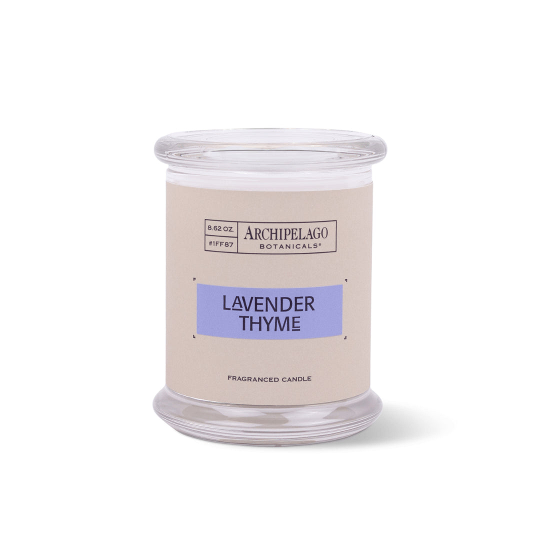 The Lavender Thyme Jar Candle is a clear glass soy wax candle with a beige label featuring a purple scent name. This white French Lavender candle offers an essential oil fragrance.1