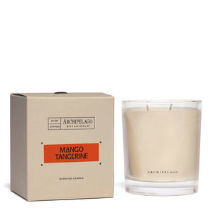 A glass jar candle labeled Archipelago sits beside a beige box labeled Mango Tangerine Credenza Candle. The box features a bold orange label, hinting at lively citrus and mango notes inside.1