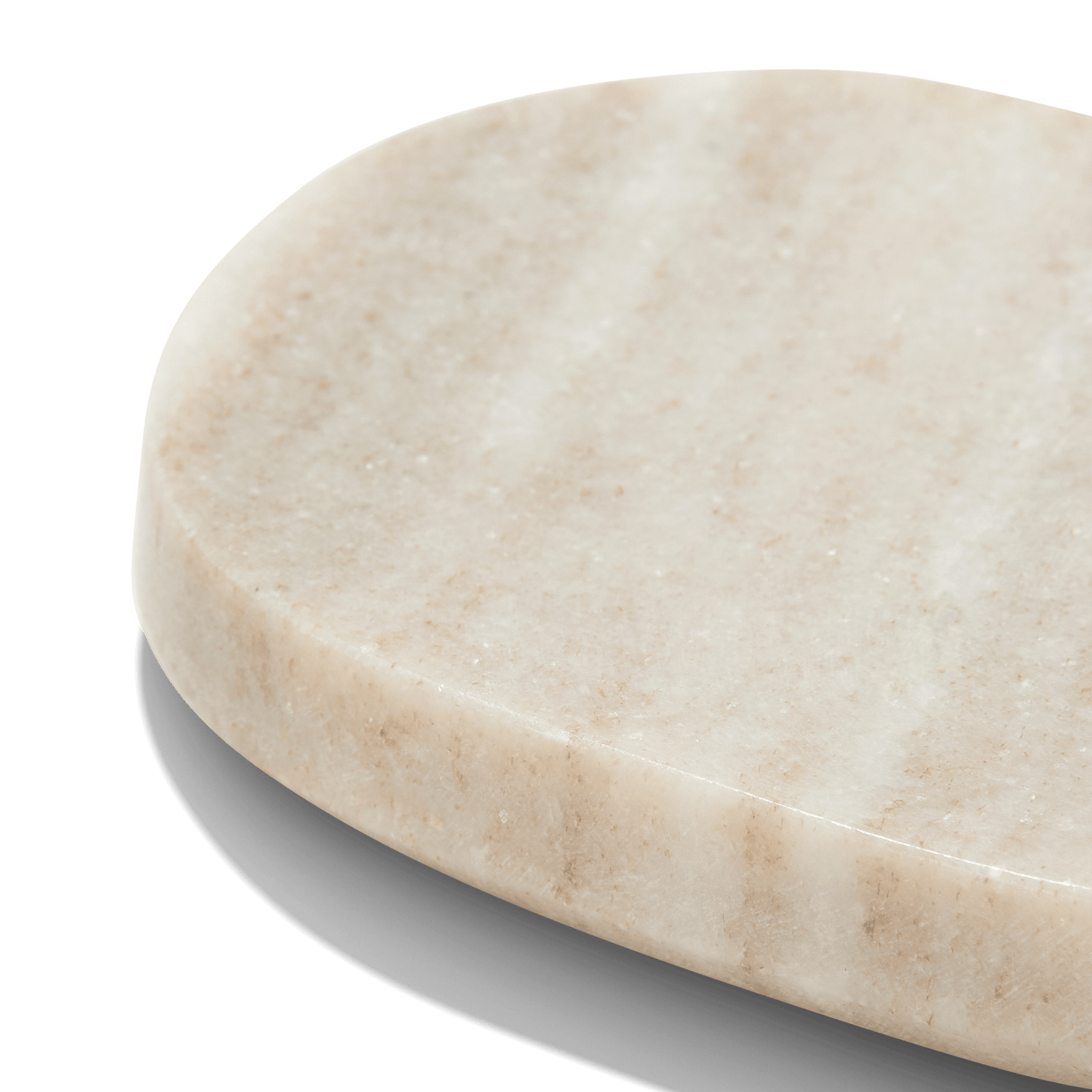 Close-up of the Marble Soap Dish, featuring a smooth oval shape and subtle natural striations, casting a gentle shadow on a white surface—an elegant accessory for a spa-inspired bathroom.4