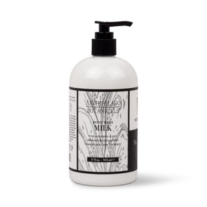 White 17 oz. Milk Body Wash bottle with a black pump dispenser and a label featuring black-and-white abstract art and text. - image 1