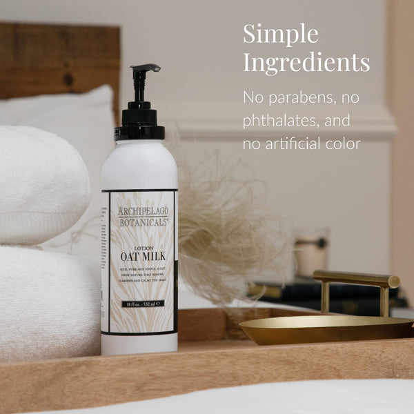 A bottle of Oat Milk Body Lotion rests on a wooden tray beside a towel, with text that reads: Simple Ingredients. No parabens, no phthalates, no artificial color. Enriched with nourishing milk solids, this oat lotion provides gentle hydration for healthy skin.