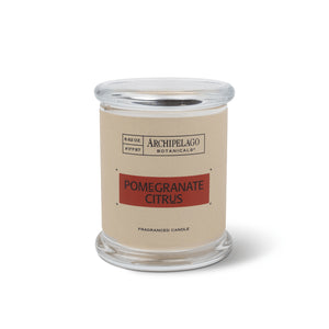The Pomegranate Citrus Jar Candle is a clear glass jar candle with a beige label. Made from a soy-wax blend, it features a round glass lid and is shown on a white background.1