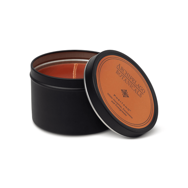 Black tin candle with a brown label on a white background