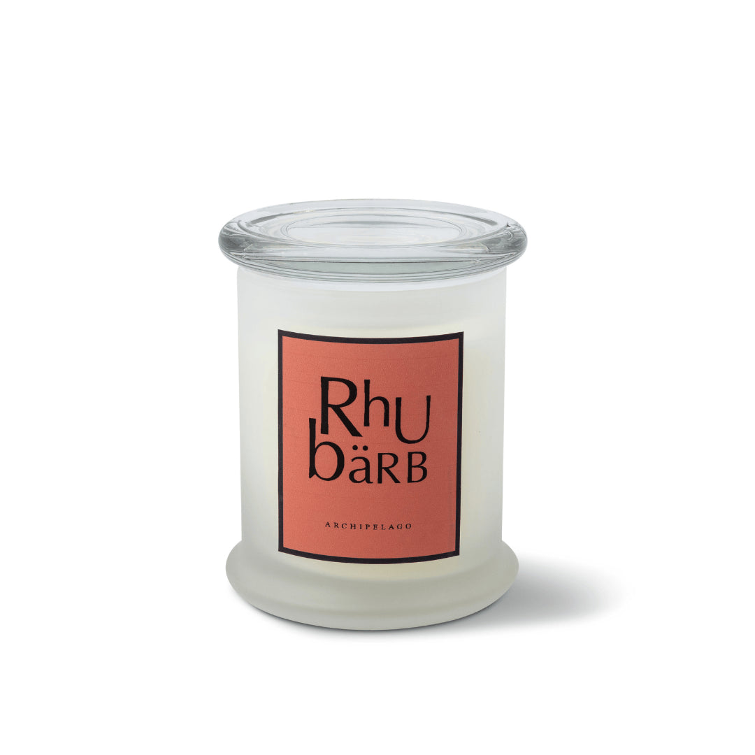 The Rhubarb Frosted Jar Candle is a hand-poured candle in a white frosted jar with a clear glass lid and coral label featuring "Rhubarb" and "Archipelago" in black, displayed against a plain white background.1