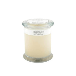 The Savannah Jar Candle is a clear glass apothecary-style candle with white wax and a glass lid. Its label reads Archipelago Botanicals, and it gently infuses the room with the fragrance of essential oils.1