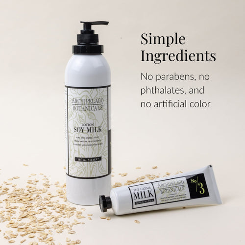 Two Soy Milk Body Lotion bottles from Archipelago Botanicals on a light surface, surrounded by oats. Text reads: Simple Ingredients. Our Soy Milk Body Lotion is cruelty-free, with no parabens, no phthalates, and no artificial color.