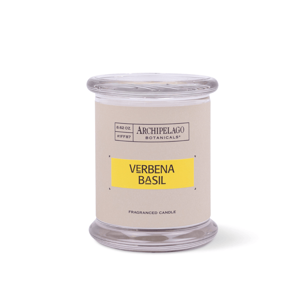 The Verbena Basil Jar Candle, with a beige and yellow label, stands upright on a white background and features an essential oil fragrance for a refreshing scent experience.