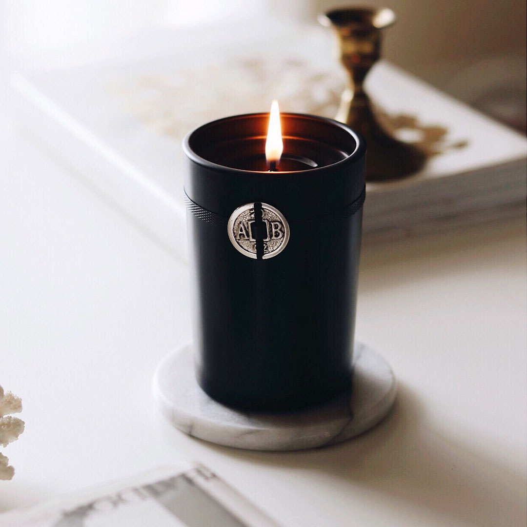 A lit Black Forest Candle with a single flame.